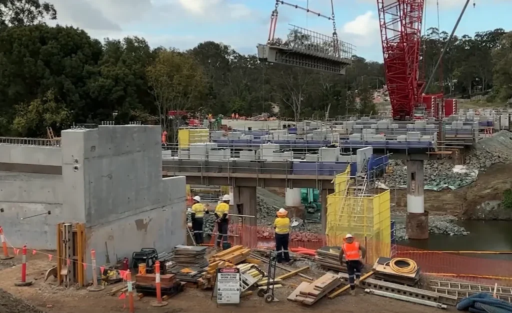 Crane lifting girder above the construction site